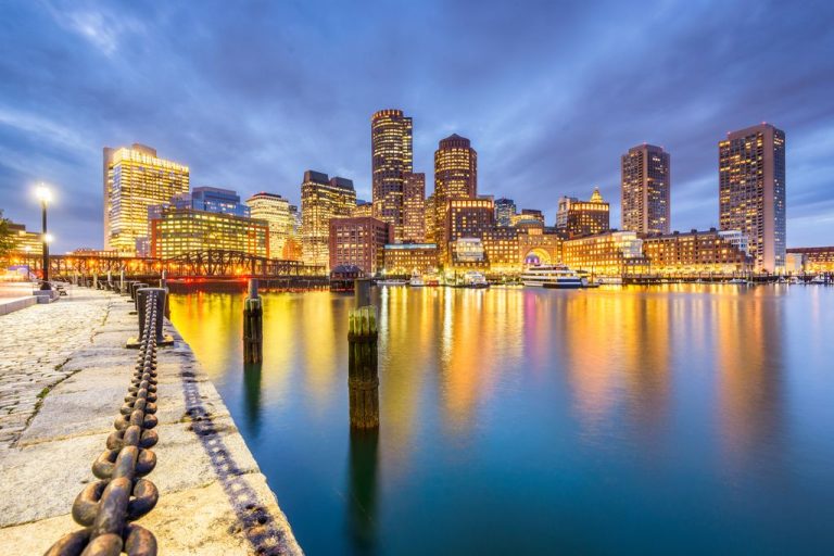 Boston, Massachusetts, USA downtown city skyline from the harbor at dusk.